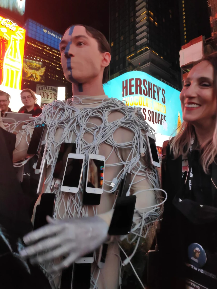 Person dressed in phones and cables at Times Square, NFT NYC 2021, not the real Pak
